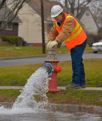 City worker flushing fire hydrant